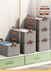 Stack of grey foldable storage bins with leather handles and size measurement labels