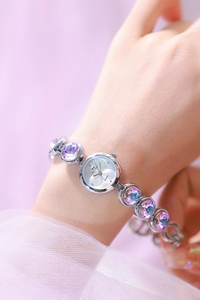Gros plan d'une montre à quartz de luxe avec des pierres précieuses irisées violettes