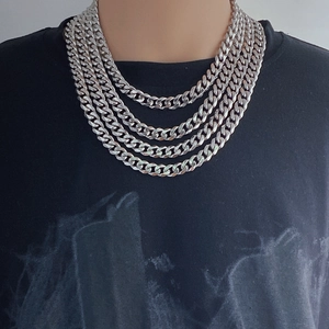 Unisex silver Cuban link chain necklace worn in a layered style for a streetwear look