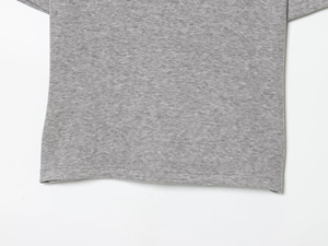 Close-up of the hemline on grey knit polo set showing fine stitching and soft fabric texture