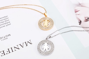 Detail of gold girl and silver boy pendants with hollowed frame and crystal inlay