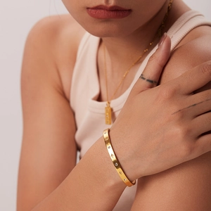 Goldener Armreif mit Zirkonia-Sternen und Halskette an weiblichem Model