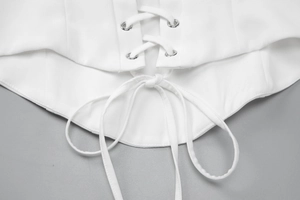 Detail shot of the adjustable lace-up back with metal eyelets on a white slim-fit dress