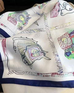 Close-up of silk square scarf featuring paisley leopard print and hand-drawn Paris illustration