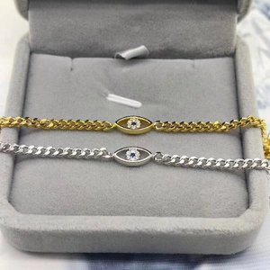 Makroaufnahme von Silber- und Gold-Augenarmbändern mit blauem Zirkonia in einer Schmuckschatulle