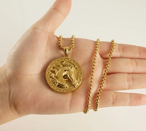 Detailed macro view of gold 3D horse head relief pendant on stainless steel box chain