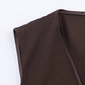 Detailed close-up of V-neckline and seam stitching on brown asymmetrical lace top