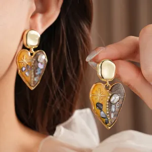 Vintage heart earrings with pearls and golden asymmetric design in retro artistic style