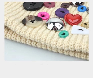 Gros plan détaillé de boutons colorés en forme de cœur sur le tissu en maille de bonnet