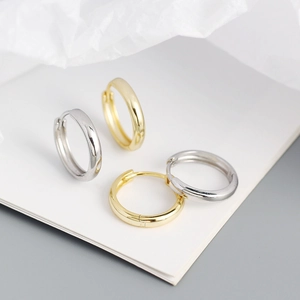 Detailed view of polished S925 silver hoop earrings in gold and silver finishes