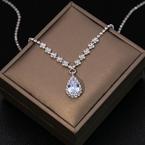 Detailed view of silver zircon water drop pendant and square diamond chain on jewelry box