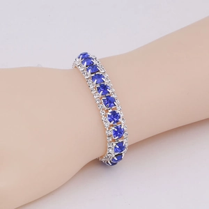 Close-up of elegant silver bracelet with deep blue oval zircons and small diamonds