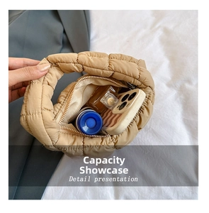 Internal storage view of beige quilted cloud bag with phone and perfume items
