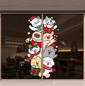 Christmas window decals with cartoon cat and dog figures on a glass sliding door