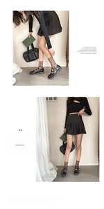 Dettaglio di calze in pizzo jacquard scuro abbinate a scarpe Mary Jane nere e gonna a pieghe