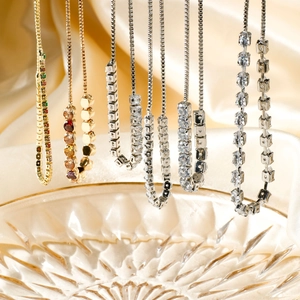 Elegant adjustable gold and silver necklaces with crystals on soft silk backdrop