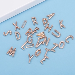 Rose gold A-Z letter charms for DIY bracelets with polished metallic finish on blue background
