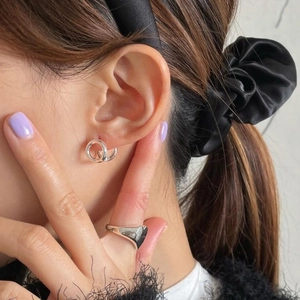 Polished 925 silver crossover hoop earrings and minimalist heart ring on a fashion model