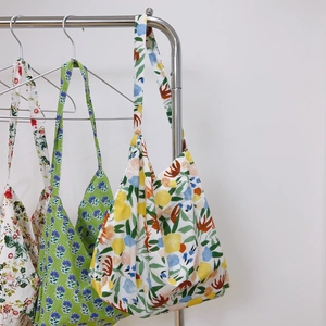 Detailed close-up of floral print cotton tote bags with three diverse artistic patterns