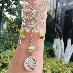 Detail of silver butterfly and moon suncatcher with crystal beads in outdoor light