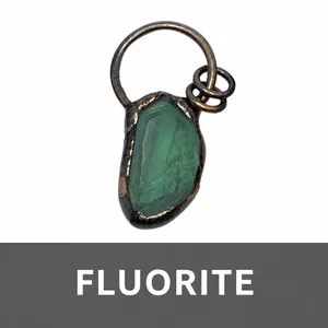Detailed view of raw green fluorite pendant with vintage oxidized copper metal frame