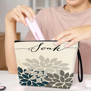 Floral canvas makeup bag with black zipper and soak print shown in a use scene