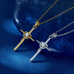 Detail of silver and gold cross pendant necklaces with heart and sparkling round zircon