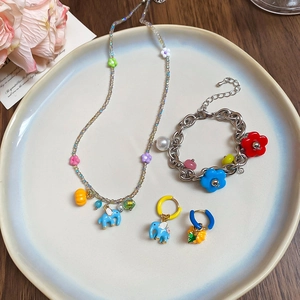 Detailed set of stainless steel necklace, bracelet and earrings with colorful pendants