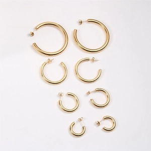 Detailed set of four pairs of polished gold C-shape hoop earrings in varying sizes