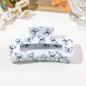 Close-up of white PVC hair claw clip featuring elegant blue butterfly patterns