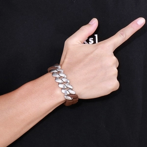 Close-up of industrial silver Cuban link chain combined with dark brown leather braid