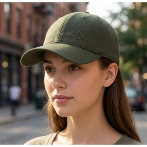 Détail de la broderie FS FASHION sur une casquette de baseball camouflage verte avec œillets