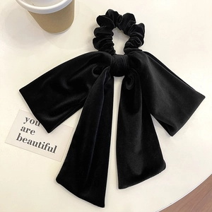 Elegant black velvet hair scrunchie with large bow streamer on white background