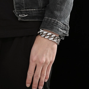 Detail eines silbernen Panzerarmbands am Handgelenk mit robuster Edelstahl-Gliederkette