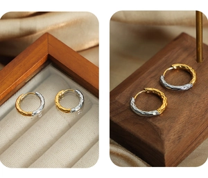 Detail of gold and silver mixed tone earrings with hammered metal texture design