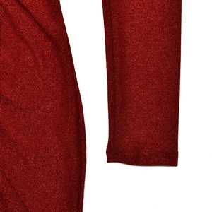 Gros plan sur la texture du tissu rouge scintillant et les coutures de la robe