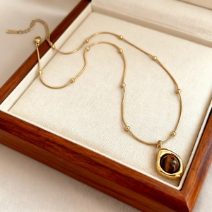 Golden bead necklace with tiger eye stone pendant in a premium wooden jewelry box