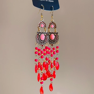 Detail of bohemian pink beaded tassel earrings with vintage bronze leaf and crystal accents