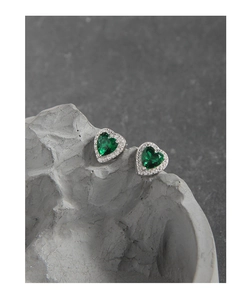 Macro detail of S925 silver heart stud earrings with green zircon and halo setting
