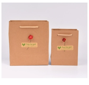 Detail showing two sizes of brown kraft paper gift bags with decorative red rose stickers