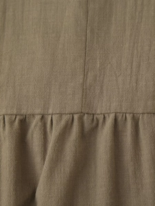 Macro shot of dark khaki linen fabric texture with seam stitching and pleat details
