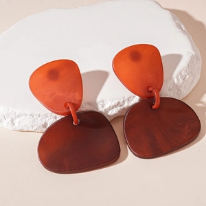 Vue détaillée des boucles d'oreilles géométriques en résine acrylique ambrée