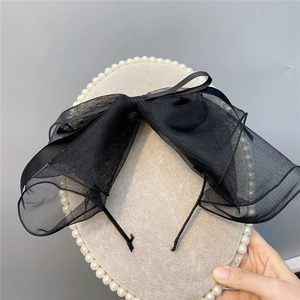 Elegant black polka dot mesh bow headband with a delicate layered tulle veil style