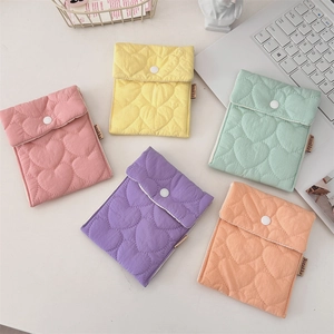 Flat lay of five quilted heart pattern storage bags in vibrant pastel candy colors