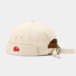 Detailed view of adjustable metal buckle and cute mushroom embroidery on canvas brimless cap