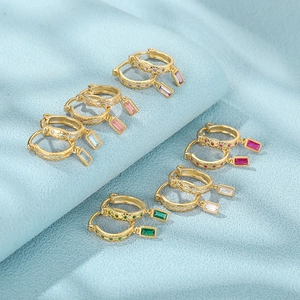 Detail of six pairs of gold huggie earrings with colorful emerald-cut zircon pendants