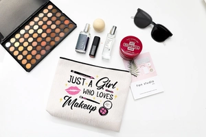 Close-up of minimalist canvas makeup bag with letter print and stylish beauty accessories
