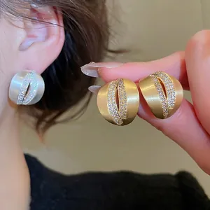 Brushed 18K gold and silver C-shaped stud earrings with rows of sparkling zircons