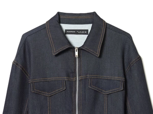 Gros plan détaillé d'une veste en jean bleu foncé avec coutures orange et fermeture éclair