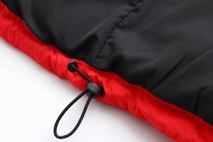 Détail de veste rouge et noire avec cordon de serrage et boucle de réglage